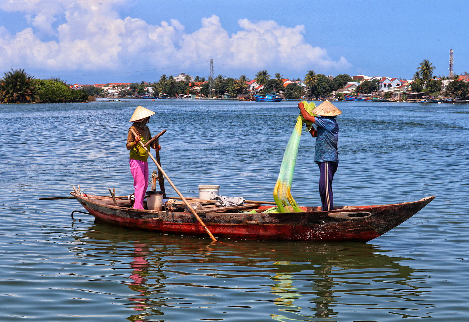 Zwei Fischer auf einem Fischerboot mit traditionelle Kleidung ziehen Fisch-Netze